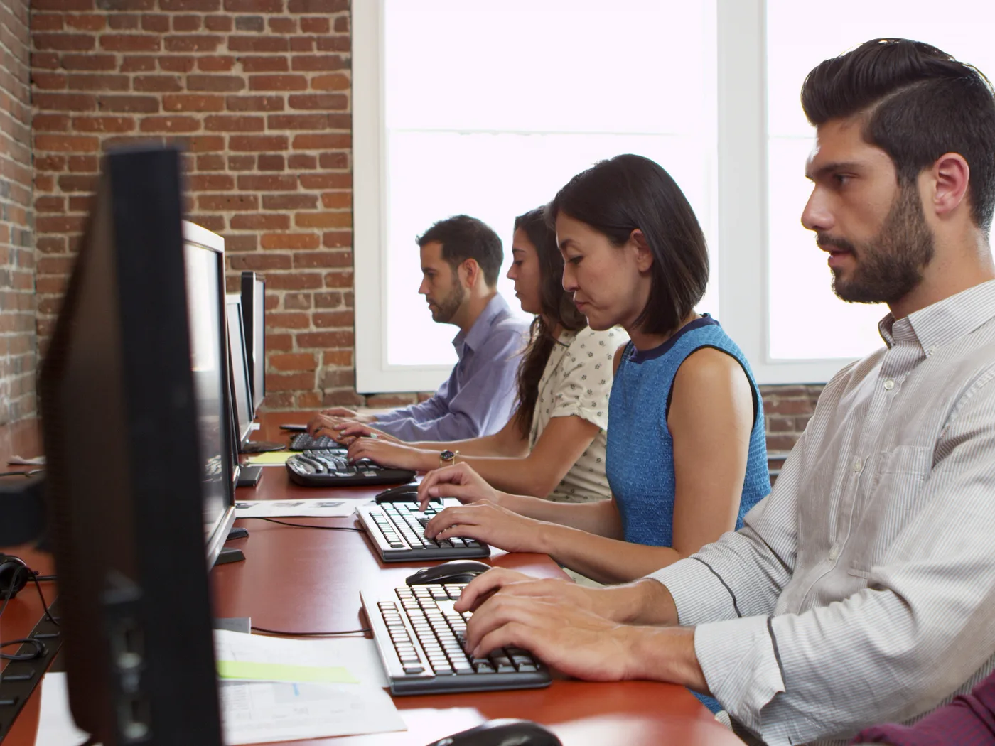 Staff working at desks in a bright office.