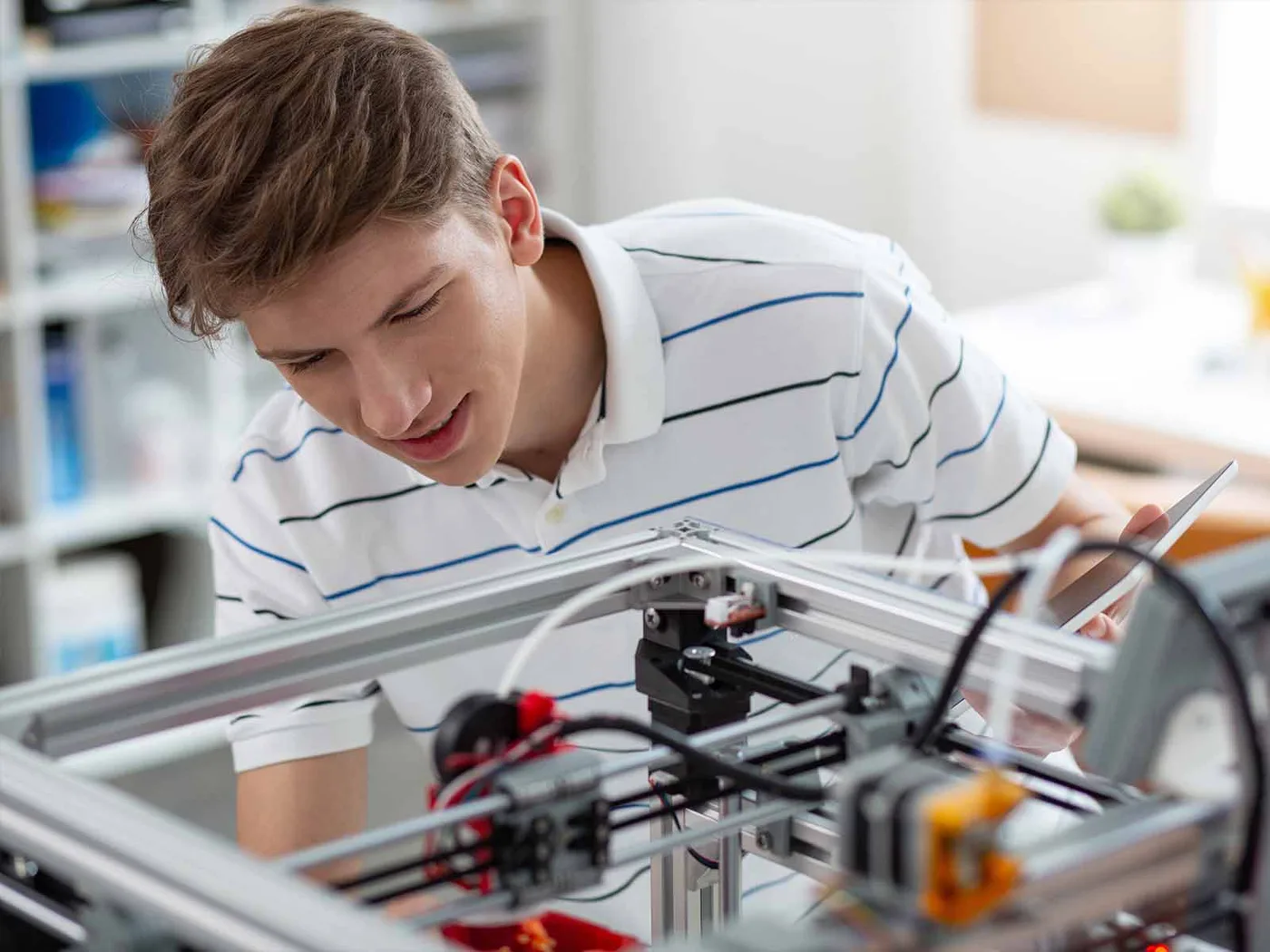 A 3D printer building a part in a technology lab.
